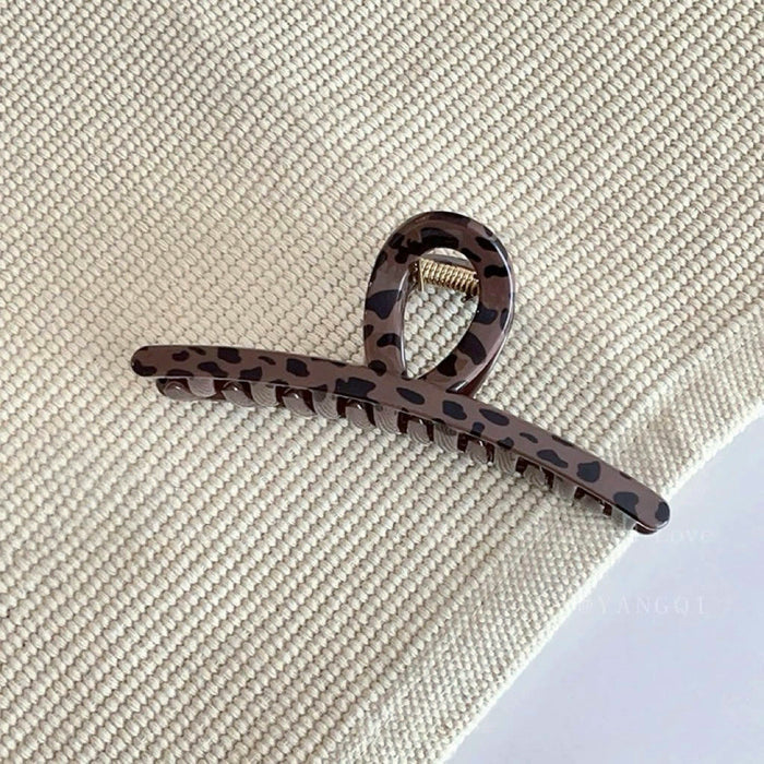 Flat lay of dark brown Leopard Print Hair Claw in one-word style, great for everyday styling and gifting.