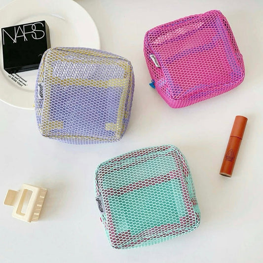 Chroma mesh pouches in pink, mint and lilac on vanity; breathable zip organizers for makeup and small essentials.
