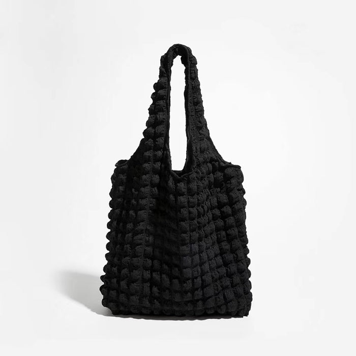 Front view of the black 3D bubble textured tote bag against a white background.