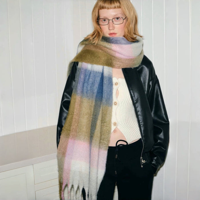 Model wearing Wool blend Cloudy Pastel Scarf with soft, muted pink, blue, green, and white stripes in beige.