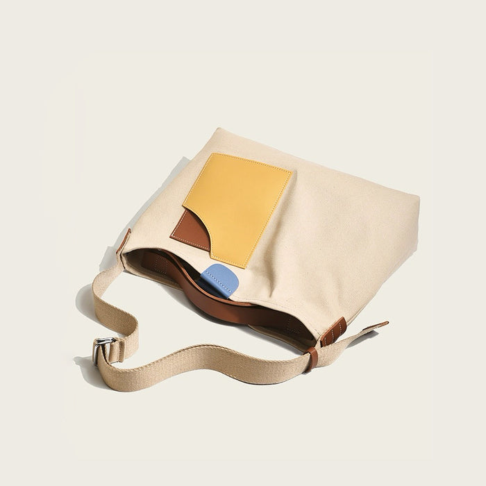 Detailed view of khaki canvas tote with yellow faux-leather accents emphasizing sturdy construction for daily shopping.