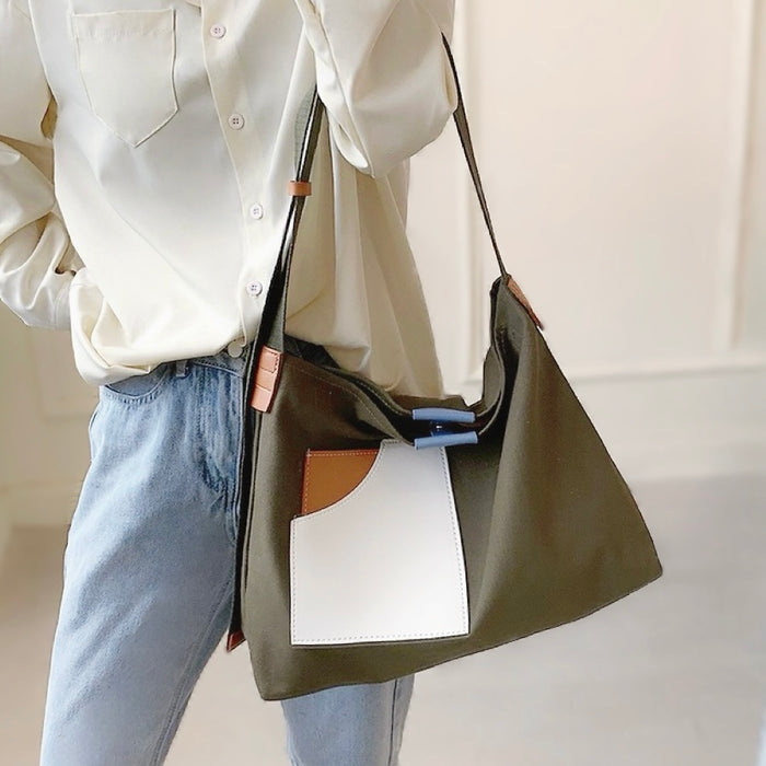Close-up of green canvas tote featuring secure magnetic closure showcasing practical and modern tech-friendly design.