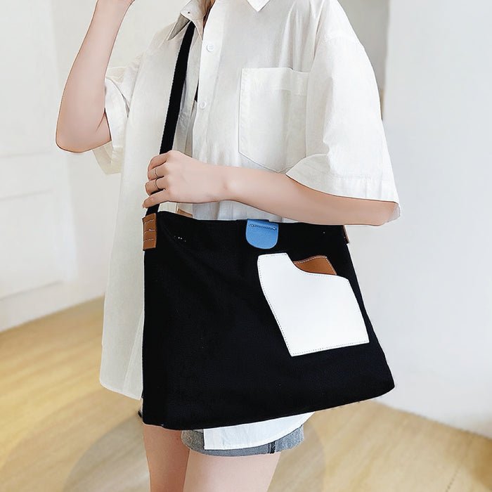 Black version of color-block canvas tote worn as crossbody bag perfect for professional office commutes.