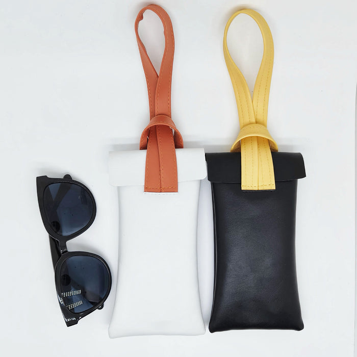 White and black glasses cases with sunglasses, portable wristlet design perfect for hands-free beach trips.