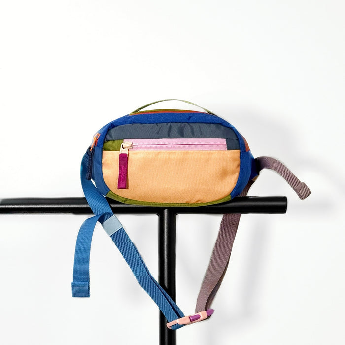 Apricot nylon belt bag displayed on a black metal stand and clean background.