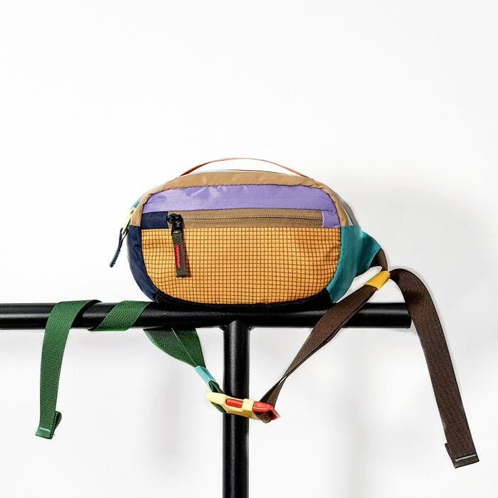 Yellow nylon belt bag displayed on a black metal stand and clean background.