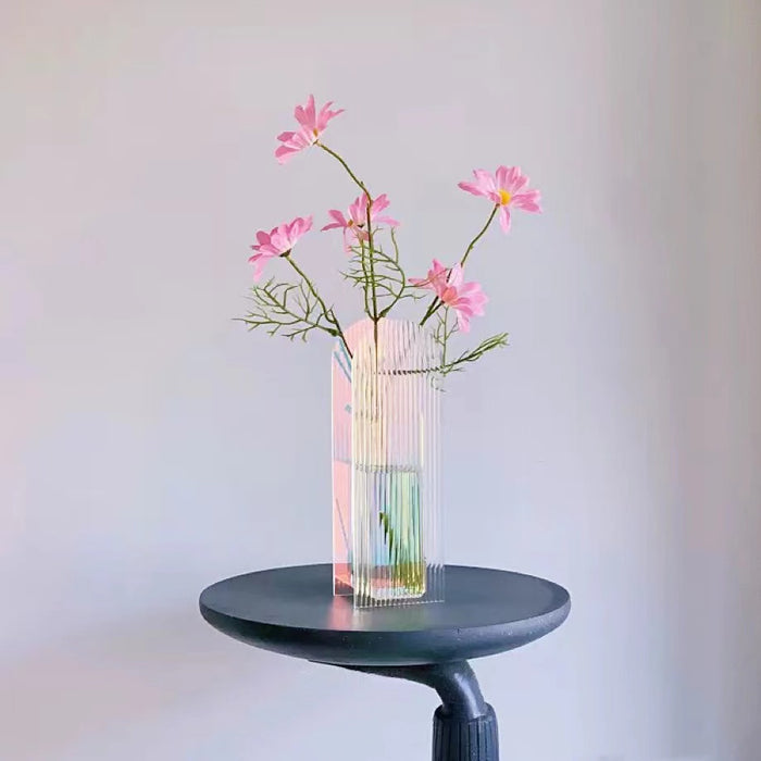 Close-up of Color Refracted Ripple Vase with flowers on a table.