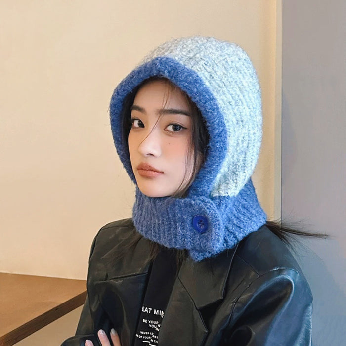 Model wearing grey-blue balaclava hat with striking color-blocked panels and a cozy wool-acrylic feel.