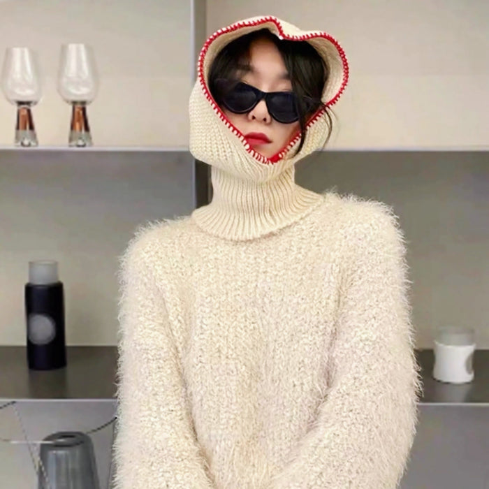 Person wearing white textured sweater and a soft-knit hood with vibrant red trim balaclava hat.