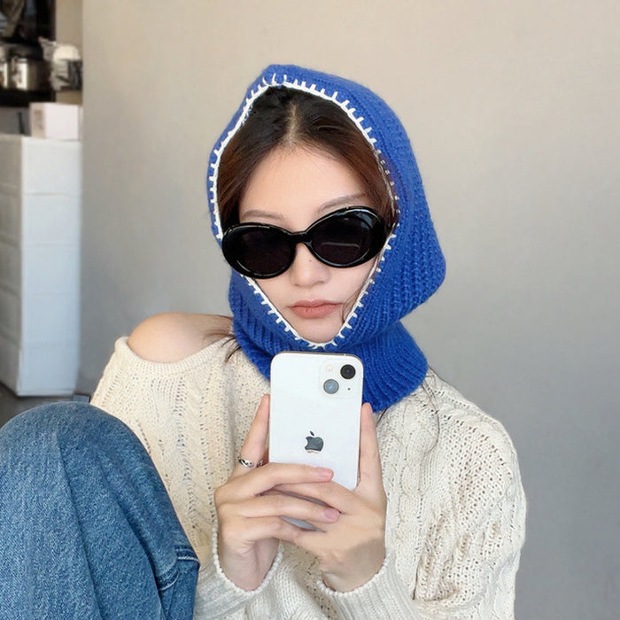 Model wearing Klein blue balaclava hat with playful contrast edges, knitted from soft cotton-acrylic.