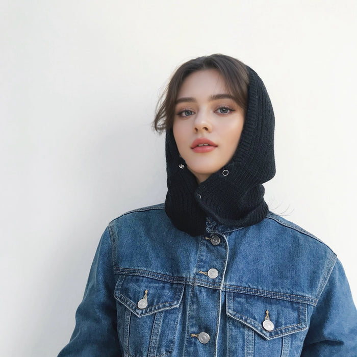 Woman wearing black knitted balaclava with snap buttons, crafted from a cozy acrylic and cotton mix.