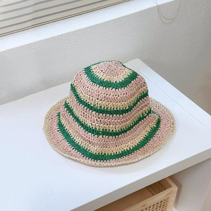 Front view of green striped foldable straw hat. Playful summer aesthetic for outdoor leisure activities.