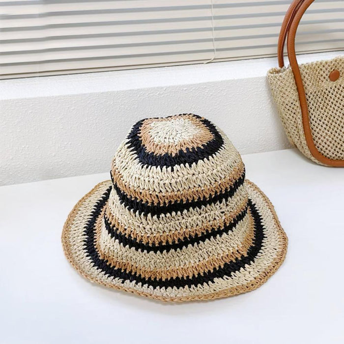Front view of black striped foldable straw hat. Timeless monochrome design for chic seaside styling.