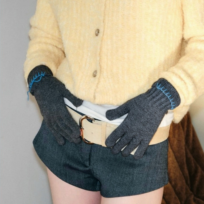 Grey colored-thread hemming gloves with visible contrast stitching; simple warmth for chilly commutes.