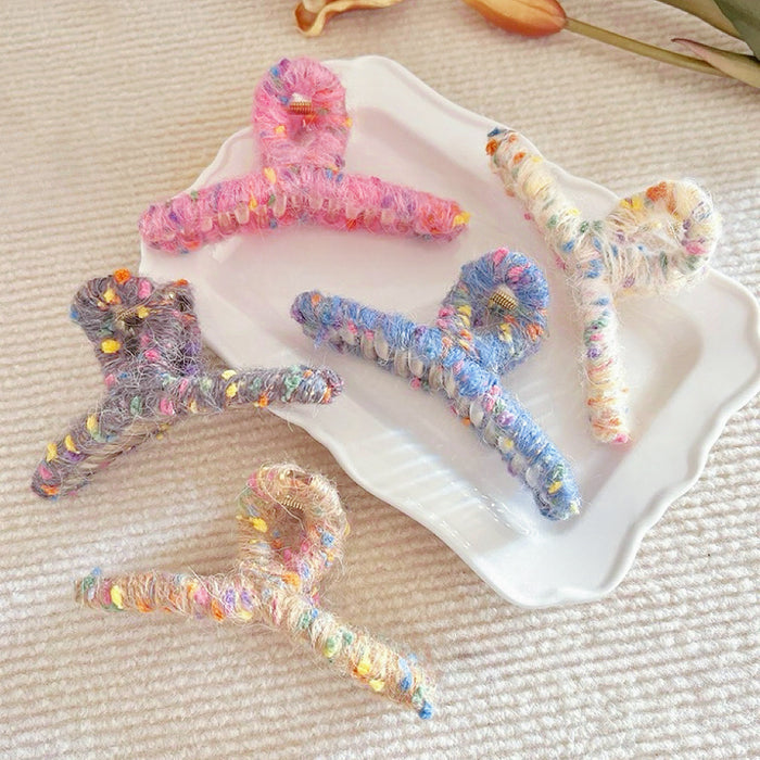Set of five colorful yarn hair claws in pink, blue, gray, khaki, and beige.