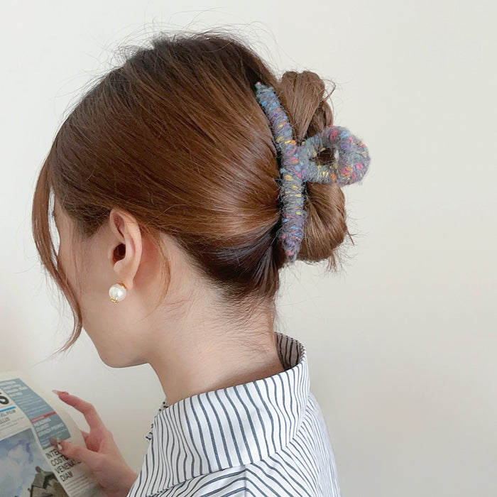 Model wearing a Colored Yarn Hair Claw  in gray, ideal for quick updos and ponytails.