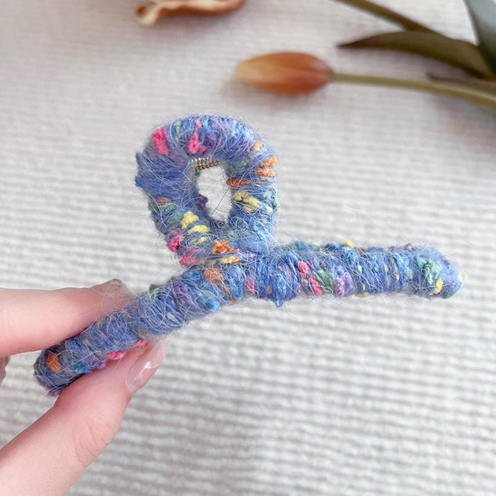 Model holding a Colored Yarn Hair Claw in hand, showcasing the texture.