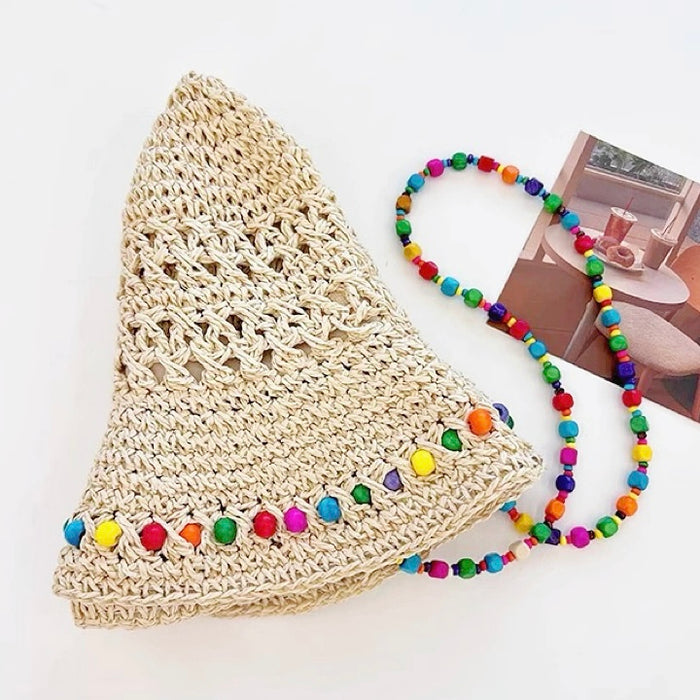 Flatlay view of the straw hat showing the removable beaded cord on a white background.