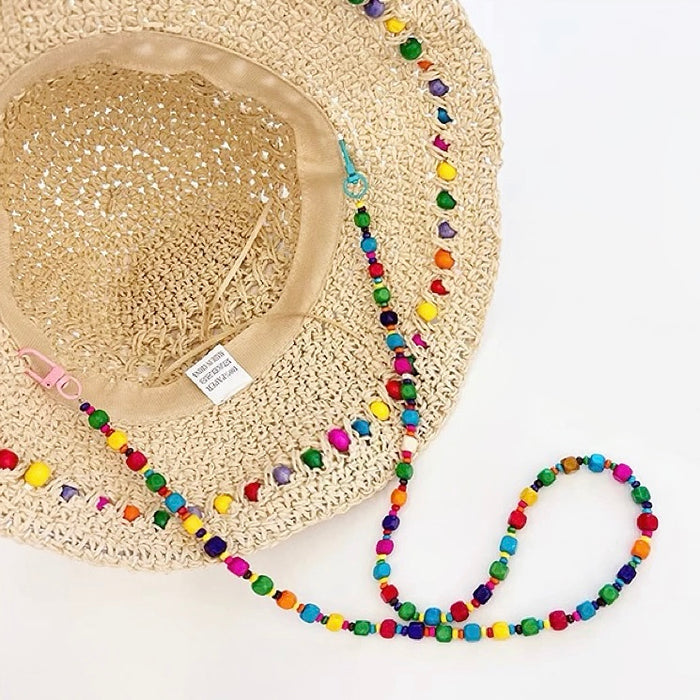 Close-up interior view of straw hat, showcasing detachable beaded cord and drawstring for adjusting head circumference.