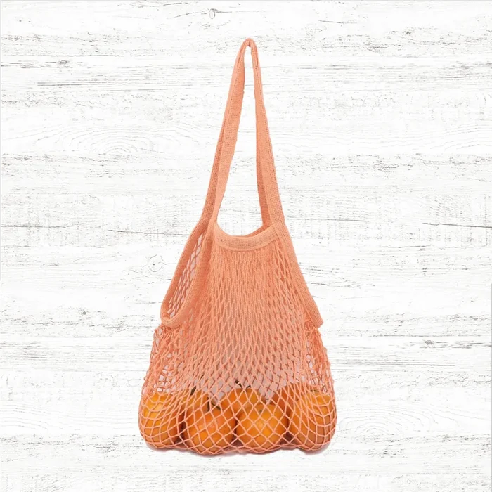 Angled view of Colorful Net Shopper Bag in orange, great for everyday carry and travel.