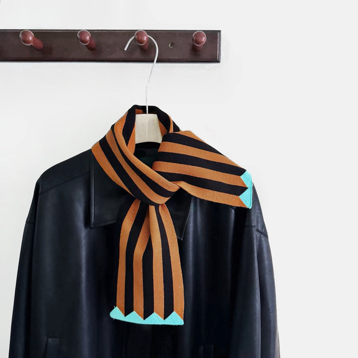 Front view of ColorPop Striped Scarf, a polyester fiber scarf with black and orange stripes and turquoise accents.