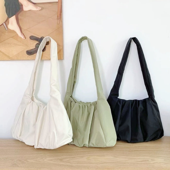 Three concise pleated shoulder bags in white, green, and black;  affordable minimalist nylon totes under $50.