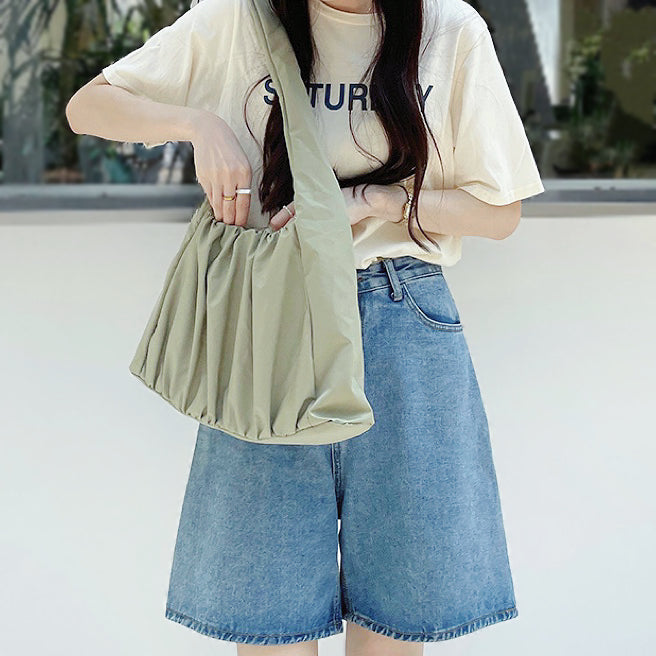 Model wearing the  green pleated shoulder bag; showcases the lightweight nylon texture and effortless urban style.