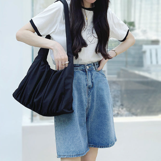 Model carrying the black pleated shoulder bag; minimalist aesthetic ideal for Office Chic and professional daily carry.