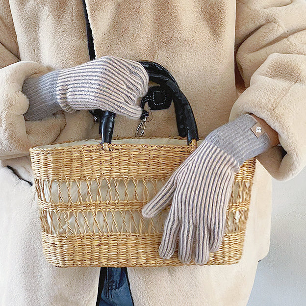 Flat lay contrast striped knit gloves with ribbed cuffs; cozy accessory for winter commuting.