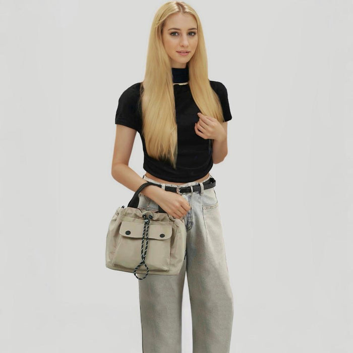 Model styling the khaki cube bag as a modern streetwear accessory.