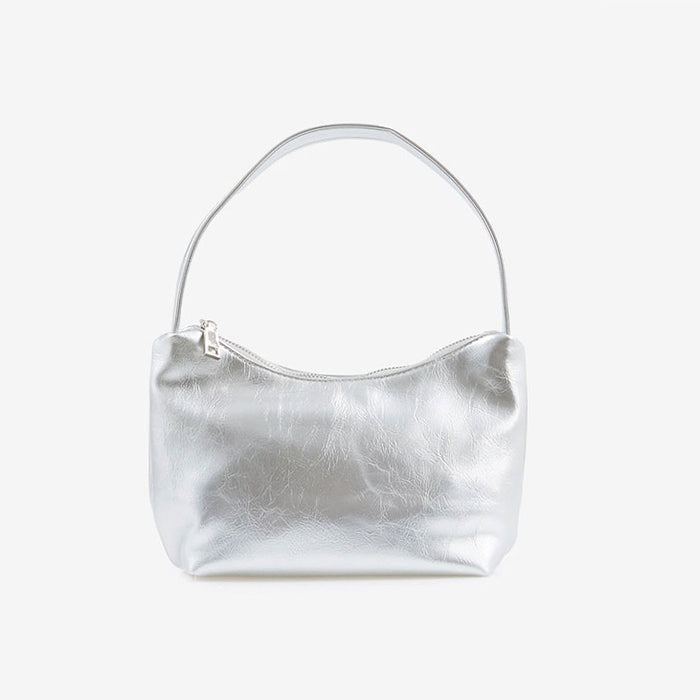 Angled view of Silver patent leather shoulder bag with a single strap and top zipper closure, easy for commuting.