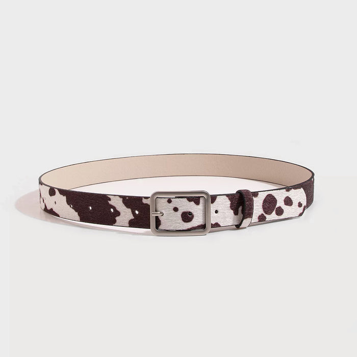 Furry faux fur belt with black and white cow print and a silver rectangular buckle.