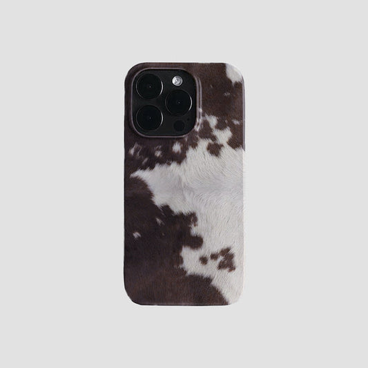 Brown and white cowhide pattern silicone iPhone case with black camera cutout. Western aesthetic style.