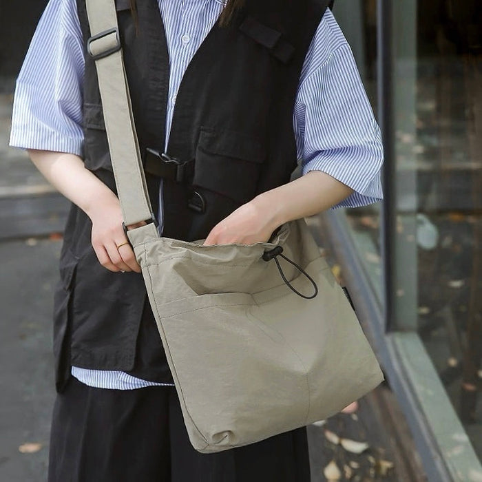Model carrying a gray green nylon bag as crossbody, great for daily carry and travel.