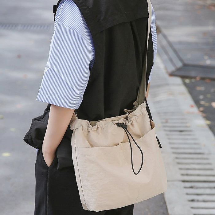 Model carrying a beige nylon bag as crossbody, easy for commuting and weekends.