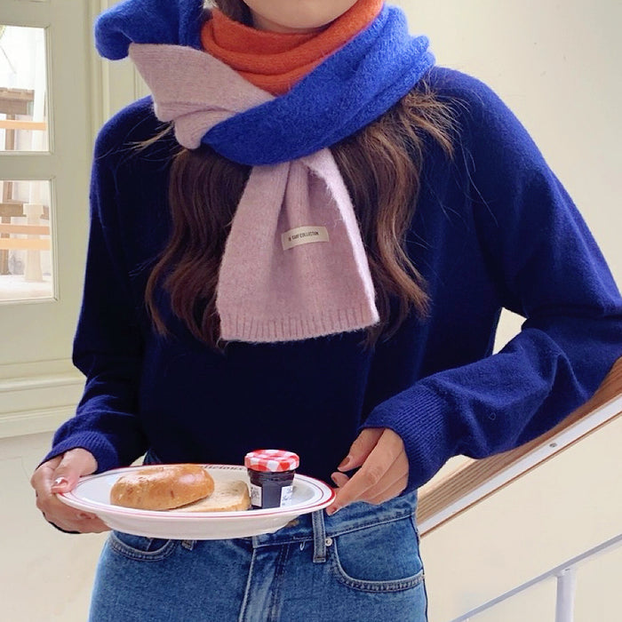 Model wearing Cozy wool-acrylic splicing color scarf in blue, orange, and pink, worn with a navy sweater.