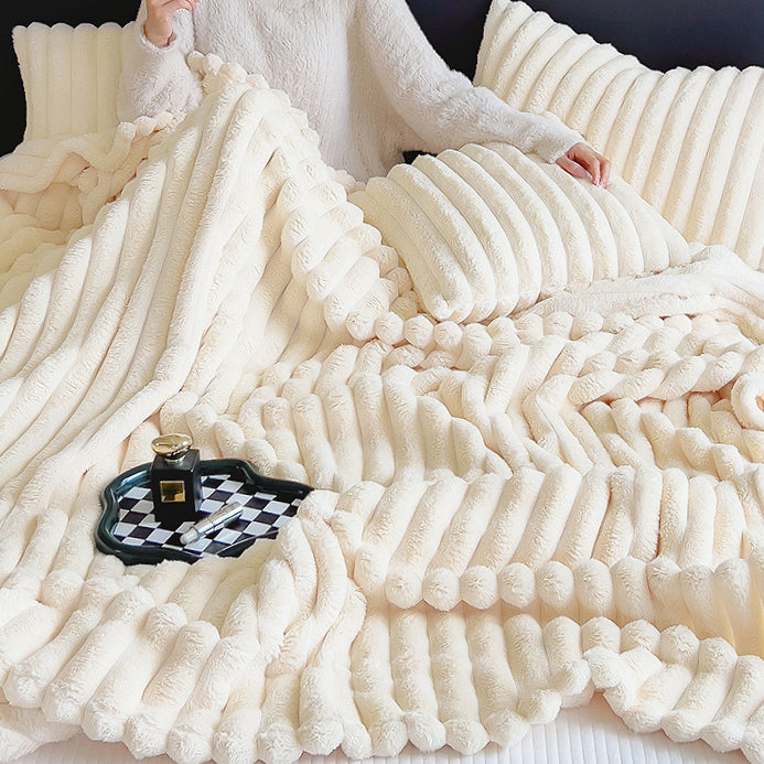 Model resting under cream wave textured fleece blanket, cozy home relaxation view.