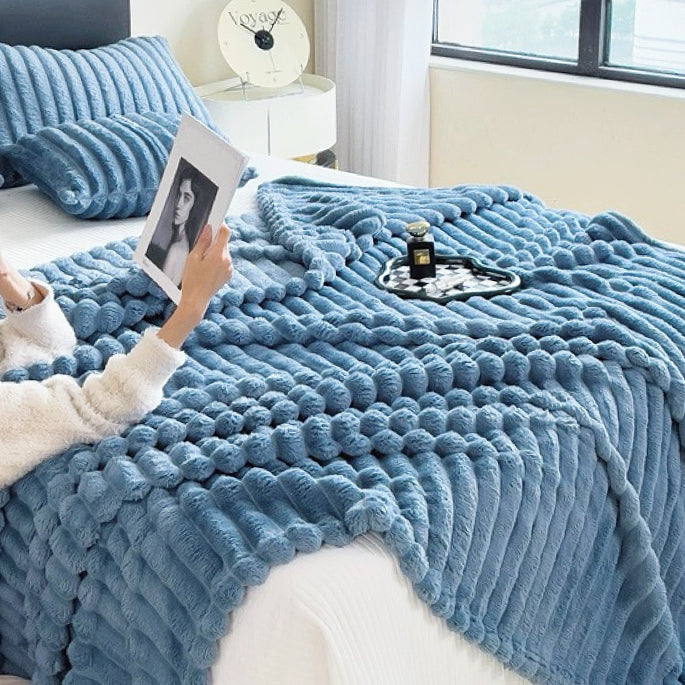 Blue wave textured fleece blanket spread on bed, vibrant seasonal home accessory.