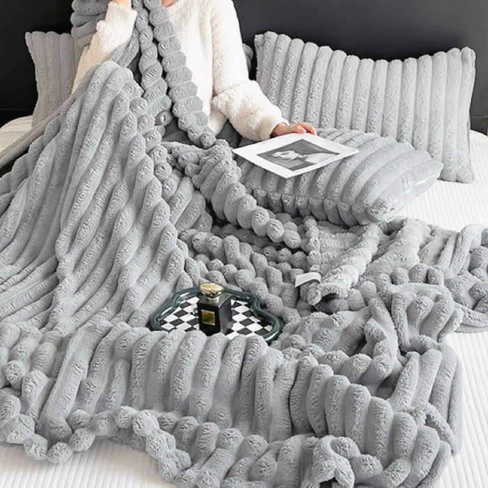 Grey polar fleece blanket with 3D wave design, minimalist neutral room decor.