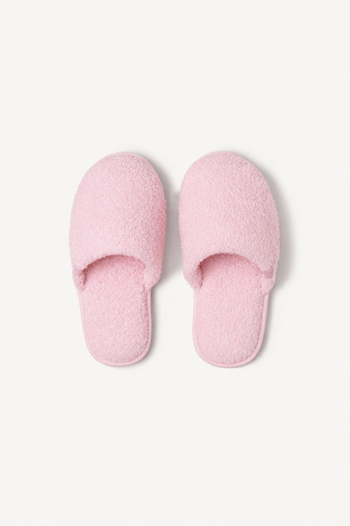 Pair of pink slippers on a light gray background