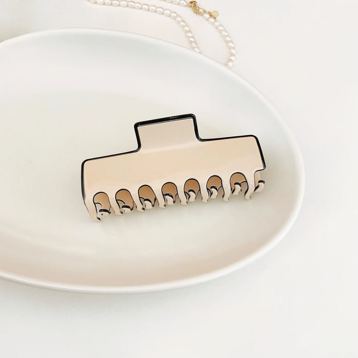 Angled view of Cream Black Border Hair Claw in rectangle shape, great for everyday styling and gifting.