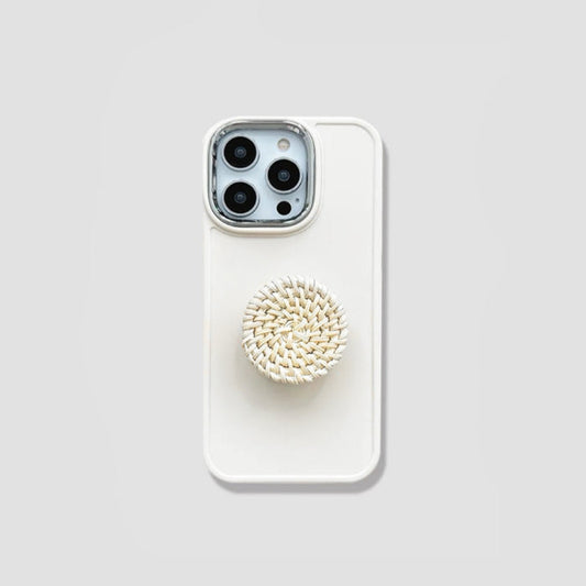 Creamy silicone iPhone case featuring a round woven rattan pop-out stand. Boho chic aesthetic.