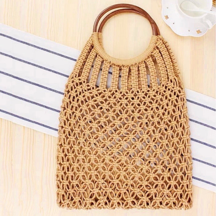 Angled view of camel cotton crochet handbag with round wooden ring handles, featuring an open-weave macrame design.