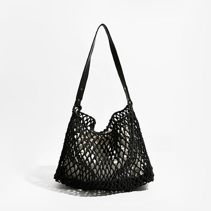 Angled view of Black crochet shoulder bag with a long leather strap and cotton rope net design, easy for commuting.