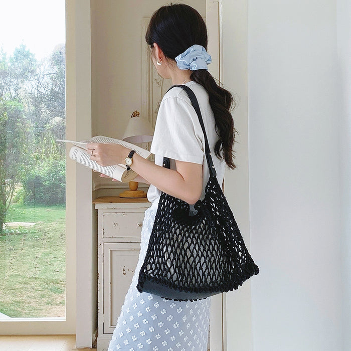 Model carrying a black Crochet Shoulder Bag With Leather Strap, ideal for city walks.