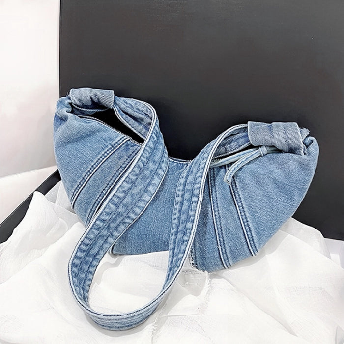 Close-up of Light blue denim croissant shoulder bag with zip-top fastening and a shoulder strap, ideal for errands.