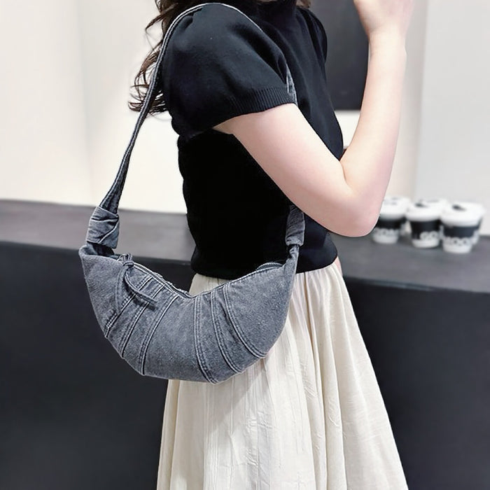 Model carrying a washed black Croissant Denim Shoulder Bag on her shoulder , great for daily carry and travel.