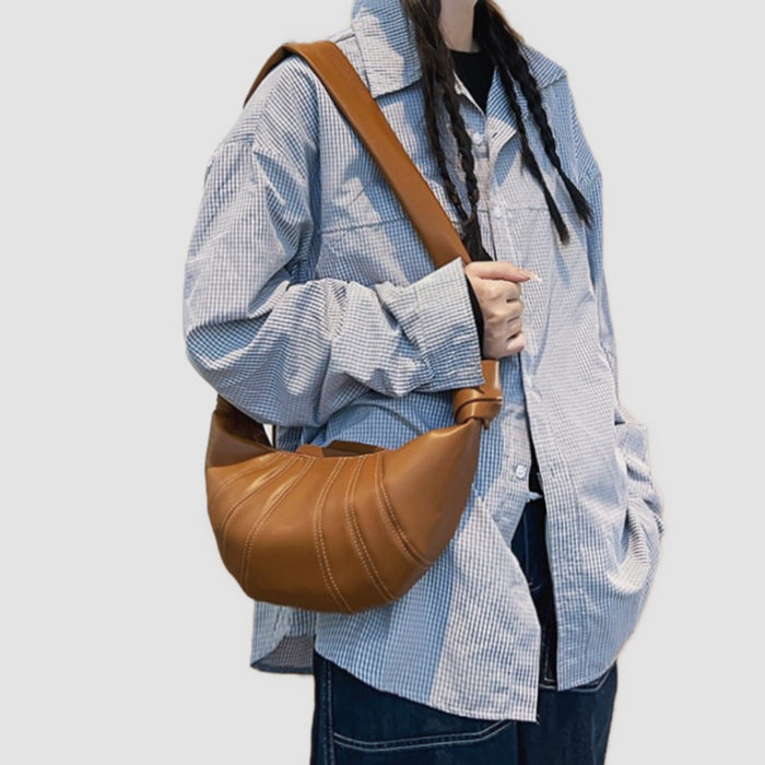 Close-up of caramel croissant bag made of premium faux leather highlighting soft tactile texture and artisanal folds.