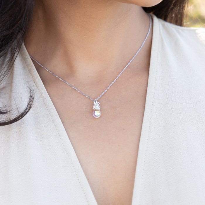 Close up of Crystal Pineapple Charm / Pendant in Sterling Silver on a woman's chest outdoors