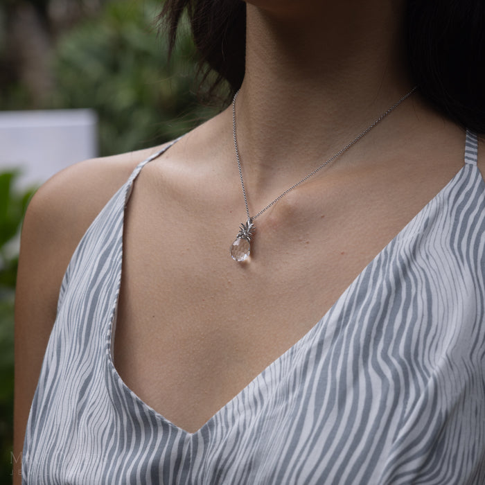 Close up of a woman in a garden wearing a Crystal Pineapple Pendant in Sterling Silver